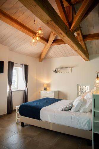a bedroom with a large bed in a room with wooden ceilings at DOMAINE FORVENT in Saint-Julien-de-Peyrolas