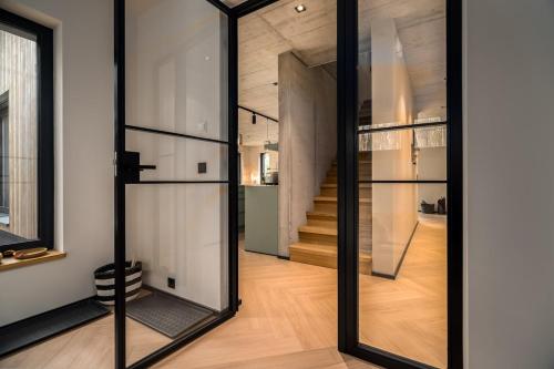 een kamer met glazen schuifdeuren en een trap bij Waldvilla Haus Gustav am Ostseestrand in Lubmin