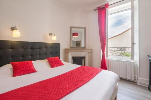 une chambre avec un lit avec des oreillers rouges et une fenêtre dans l'établissement Belle maison au coeur de Beaune avec piscine privée, Cabotte Dionysos, à Beaune