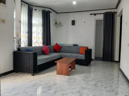 a living room with a couch and a coffee table at Dio Green House NUWRA ELIYA in Nuwara Eliya