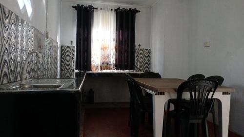 a kitchen with a table and chairs and a window at Dio Green House NUWRA ELIYA in Nuwara Eliya