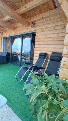 a patio with lounge chairs on the grass at Kuća za odmor Villa Kovačević in Bihać