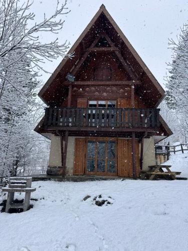 a log cabin in the snow with a deck at Chalet Le refuge in Allos