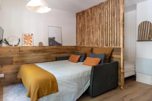 une chambre avec un grand lit avec des oreillers orange dans l'établissement L'annecien, central proche du lac, à Annecy