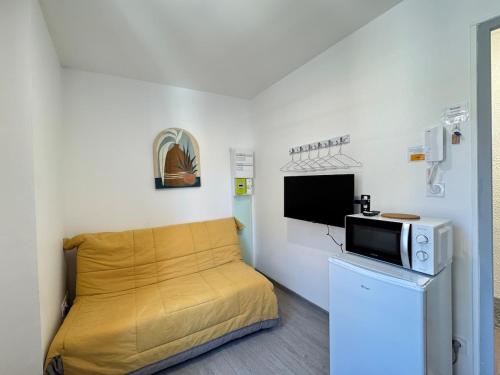 Cette petite chambre comprend un lit et un four micro-ondes. dans l'établissement Petit studio, fonctionnel 2B, à Royat
