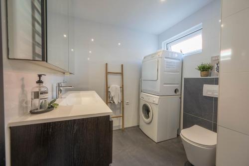 a bathroom with a sink and a washing machine at De Grote Stern in Groet