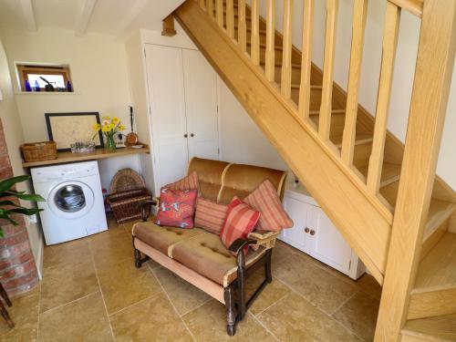 a living room with a staircase and a chair at Swallow's Flight in Askham