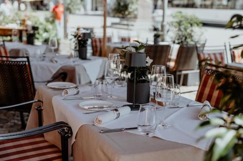 a set of tables with white table cloths and wine glasses at Boardinghouse Sonne in Offenburg