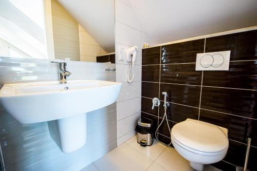 a bathroom with a sink and a toilet at Aparthotel EuforiaPort in Pisz