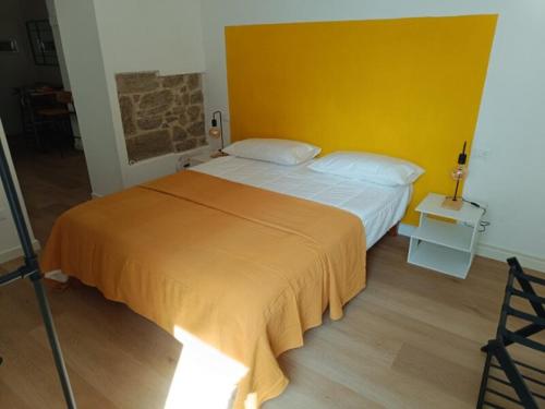 a bedroom with a large bed with a yellow headboard at Castle apartment Aga in Uzzano