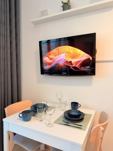 a white table with a tv on a wall at ONE Guest Place Twin Room with Shared Toilet in Abu Dhabi