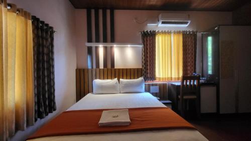a bedroom with a bed in a room with a desk at Bell Farms and Resorts in Munroe Island