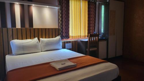 a hotel room with a bed with a towel on it at Bell Farms and Resorts in Munroe Island