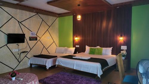 a bedroom with two beds and a green wall at Bell Farms and Resorts in Munroe Island