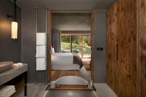 a bathroom with a bath tub and a bedroom at Six Senses Crans-Montana in Crans-Montana