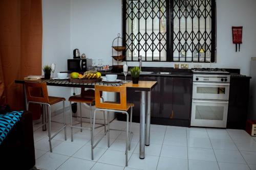 a kitchen with a island with a table and chairs at Royal London Ville Apartment in Tema Community 6 in Tema
