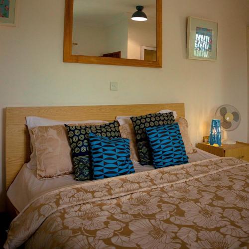 a bedroom with a bed with pillows and a mirror at Royal London Ville Apartment in Tema Community 6 in Tema