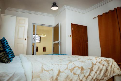a bedroom with a large bed and a mirror at Royal London Ville Apartment in Tema Community 6 in Tema
