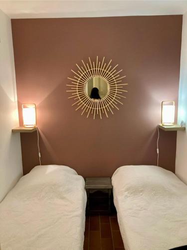 - 2 lits dans une chambre avec un miroir mural dans l'établissement Appt 27m2 - parking - clim - piscine - mer à 100m, à Roquebrune-sur Argens