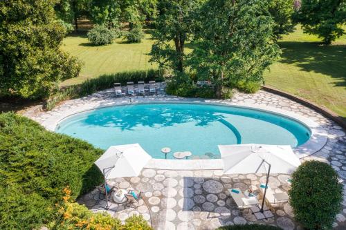 an overhead view of a pool with chairs and umbrellas at Villa La Pioppa in Pieve dʼOlmi