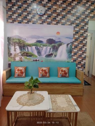a blue couch in a living room with a painting at Amazing Homestay in Guwahati