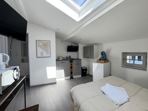 - une chambre blanche avec un lit et une lucarne dans l'établissement Petit studio, fonctionnel 2C, à Royat