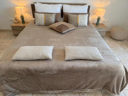 a large bed with two pillows on top of it at La Vista Residence - 5 BDS, 2 private swimming pools, stunning sea views only 10 minutes from Corfu Town's Centre in Gouvia