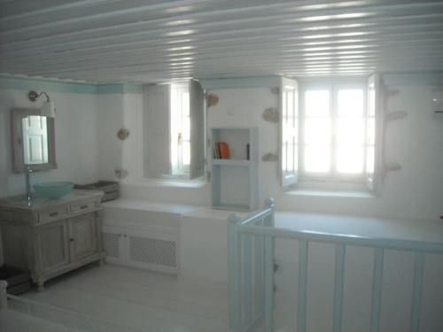 une salle de bain avec une baignoire, un lavabo et une fenêtre dans l'établissement Celene House Sapsila Patmos, à Patmos