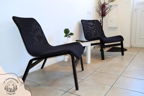 two black chairs sitting next to a white table at Le 101 de Serge in Noeux-les-Mines
