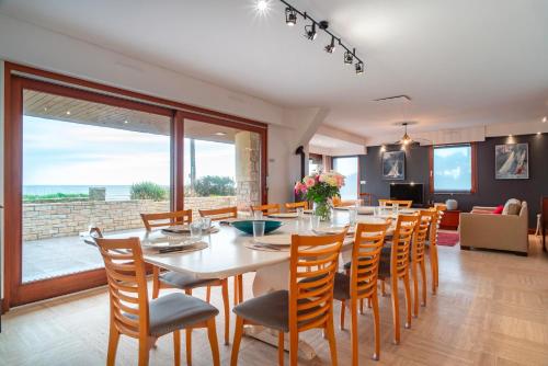 une salle à manger avec une grande table et des chaises dans l'établissement Villa St Jacques - Vue mer avec grand jardin, à Sarzeau