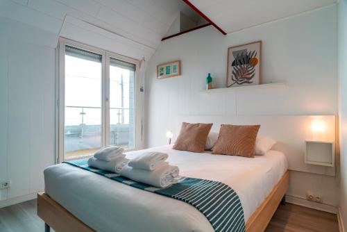 une chambre avec un grand lit avec des serviettes dessus dans l'établissement Villa St Jacques - Vue mer avec grand jardin, à Sarzeau