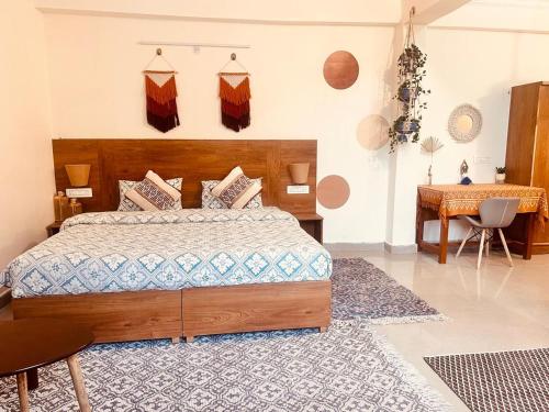 a bedroom with a large bed and a table at Getaway Stays-Rooms with private kitchen-Dharamkot in Dharamshala