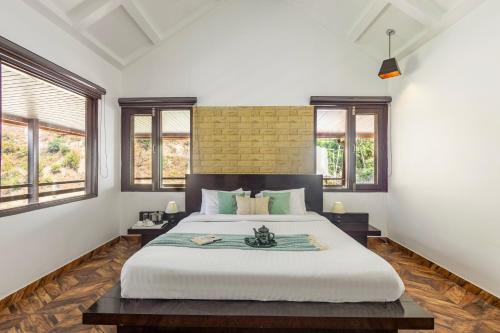 - une chambre avec un grand lit blanc et des fenêtres dans l'établissement Alaya Stays Madhuram Villa - Pet-Friendly 5 BHK Hillside Retreat With Garden & Balcony, à Dhanaulti