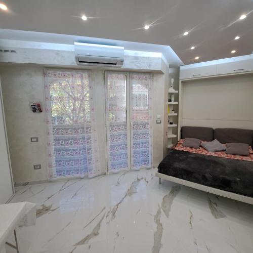 - une chambre avec un lit et un sol en marbre dans l'établissement Sharon Apartment in Victoria Beach, à Menton