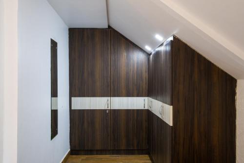 un couloir avec une armoire en bois dans une maison dans l'établissement Alaya Stays Madhuram Villa - Pet-Friendly 5 BHK Hillside Retreat With Garden & Balcony, à Dhanaulti