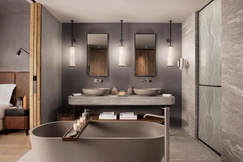 a bathroom with two sinks and a bath tub at Six Senses Crans-Montana in Crans-Montana