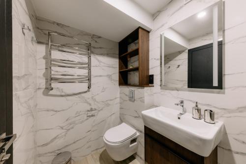 a white bathroom with a sink and a toilet at Mayak Resort in Kyiv