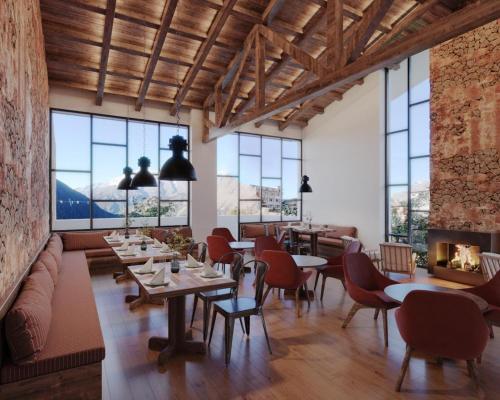 a dining room with tables and chairs and windows at The Himalayan Tyangboche in Lukla