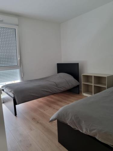 une chambre avec deux lits et une fenêtre dans l'établissement Apartements Dunkerque, à Grand-Fort-Philippe