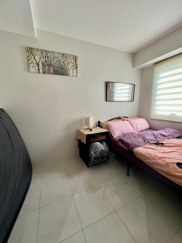 a bedroom with two beds and a table in it at Affordable Condominium in Cebu in Cebu City