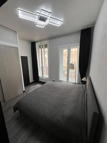 une chambre avec un grand lit et deux fenêtres dans l'établissement Superbe appartement silencieux dans l'hyper centre, à Lyon