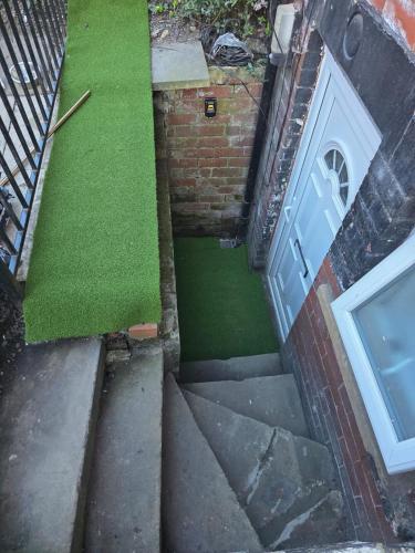 a small patch of green grass next to a door at Cozy Studio Flat, 7mins from CENTRE, Parking, WiFi & Netflix in Killingbeck