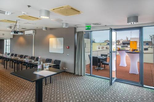 a restaurant with tables and chairs and a balcony at Hotel President in Budapest