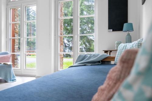a bedroom with a blue bed and windows at Horní Mísečky - I3 Pohodlný a teplý apartmán u sjezdovky in Horni Misecky