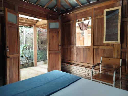 a room with a bed and a chair in it at Banyu Kasongan Homestay in Bantul