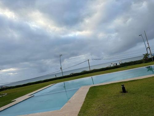 ein großer Swimmingpool mit dem Meer im Hintergrund in der Unterkunft Appartement à Dar bouaaza in Tamaris