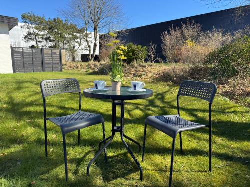two chairs and a table in the grass at Briks and Dreams in Billund
