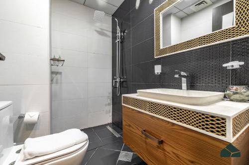 łazienka z umywalką, toaletą i lustrem w obiekcie Cozy Studio with City Views at Bayz by Danube by BMS w Dubaju
