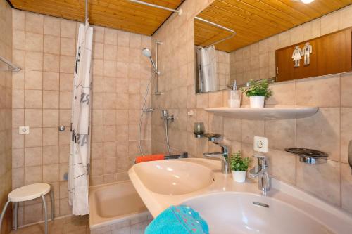 Un baño con lavabo, ducha y bañera. en Kuckucksnest, en Bad Herrenalb