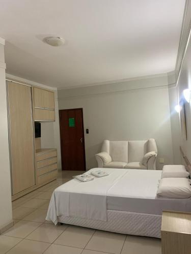 a white bedroom with a bed and a couch at Hotel Eduardus in Palmas